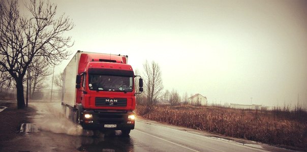 Грузоперевозки Тюмень Транспортные услуги фура едет по дороге в России брызги разлетаются